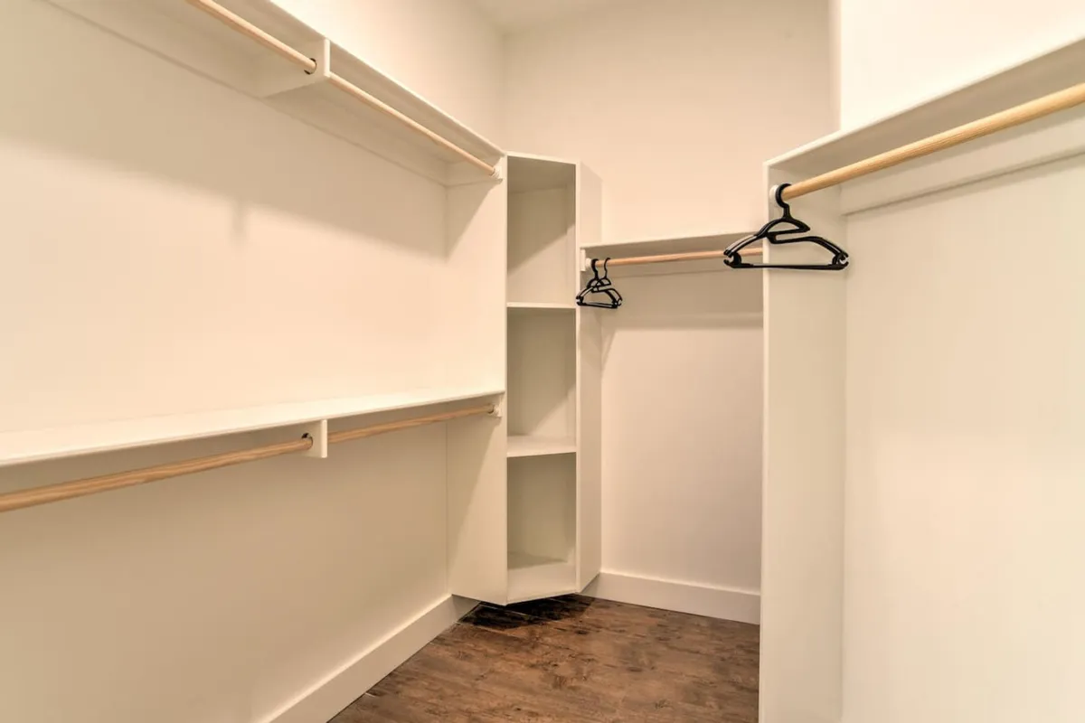 A practical storage area with open shelves, multiple hangers, and a tidy storage unit—ideal for organizing clothing and travel essentials. The space is functional yet thoughtfully arranged for convenience.